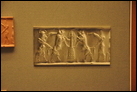 Аккадская цилиндрическая печать (отпечаток крупным планом). Из Месопотамии, ок. 2300-2150 гг. до Р.Х. Британский музей. ME 89308. Изображены человекобык и обнаженный герой, которые напали на двух разъяренных бизонов. Каждый из них находится по разные стороны холма, на котором растёт дерево.