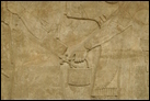Сцена суда (фрагмент; см. также предыд. и след. фото). Нимруд, ок. 865-860 гг. до Р.Х. Британский музей. WA 124564-6. Царь Ашшурнацирапал восседает среди слуг. Эта группа оружена парой крылатых духов-хранителей. Мастерство этих панелей превосходно: одежда изобилует детально проработанными прорезями, на обуви сохранились следы краски.