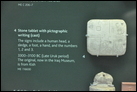 Табличка с пиктографическим письмом. Камень. Из Месопотамии (г. Киш), 3300-3100 гг. до Р.Х. Британский музей. ME 116630. Символы обозначают человеческую голову, сани, ногу, руку и цифры от одного до трех.