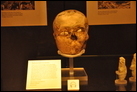 Череп. Гипс, Иерихон, ок. 7200 г. до Р.Х. Британский музей. МЕ 1274142. Большая часть наших знаний о раннем, докерамическом периоде неолита происходит из раскопок в Иерихоне, где был найден данный гипсовый череп. У черепов, подобных этому, нижняя челюсть была удалена, а лицо вылеплено из известкового гипса. Ракушки помещали в глазницы, иногда красно-черной краской изображали черты лица, волосы и даже усы. Данный артефакт может свидетельствовать о широком распространении культа предков.