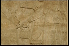 Сцена суда (фрагмент; см. также предыд. фото). Нимруд, ок. 865-860 гг. до Р.Х. Британский музей. WA 124564-6. Царь Ашшурнацирапал восседает среди слуг. Эта группа окружена парой крылатых духов-хранителей. Мастерство этих панелей превосходно: одежда изобилует детально проработанными прорезями, на обуви сохранились следы краски.