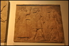 Смотр пленников. Нимруд, ок. 728 г. до Р.Х. Британский музей. ANE 118880. Эта картина является частью серии барельефов, на которых изображены пленные арабы, приведенные к царю Тиглатпалассару III. На самом краю панели справа видны руки двух пленниц. Заключенных ведут ассирийские чиновники. Изображение царя должно было находиться на панели слева.