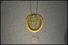 Голова вакханки и надпись. Камея-фалера. Стекло, золото. Рим. I в. Эрмитаж. ГР-12606 (Ж.219).