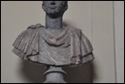 Изображение императора Траяна (53-117 гг. по Р.Х.).  Рим, Музей Киарамонти. Инв. 2079, 2081. Современное изображение размещено на серой колонне из гранита. Голова из базальта, сам бюст — из алебастра.